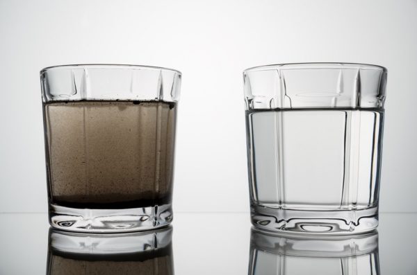 close up glasses with clean and dirty water. concept of water pollution